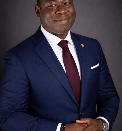 A professional head-and-shoulders portrait of a male academic staff member in a formal suit, facing the camera with a neutral, professional expression against a plain background.
